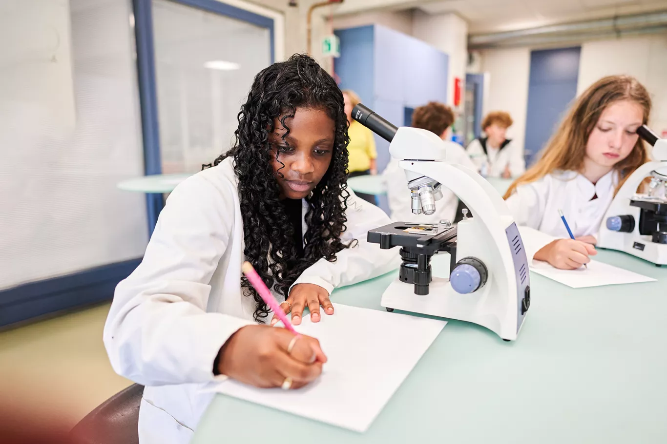 Leerlingen leren met microscopen.